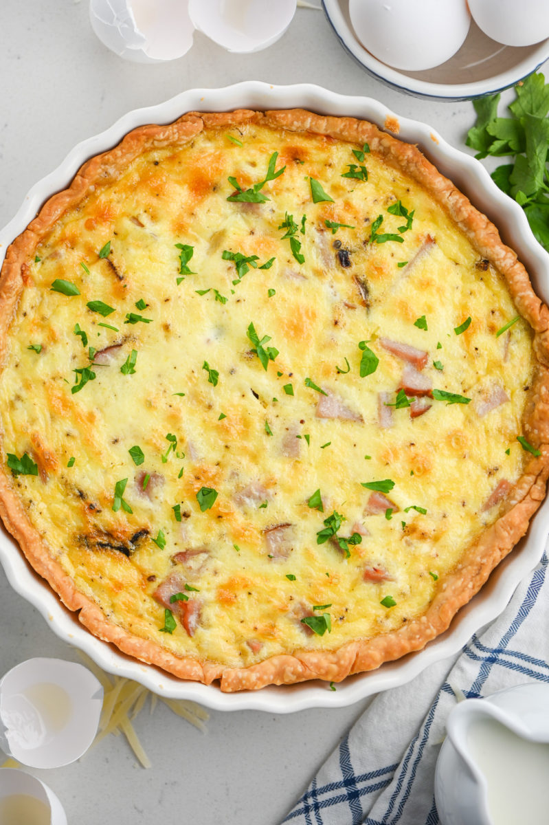 Ham and Cheese Quiche in white pie dish.