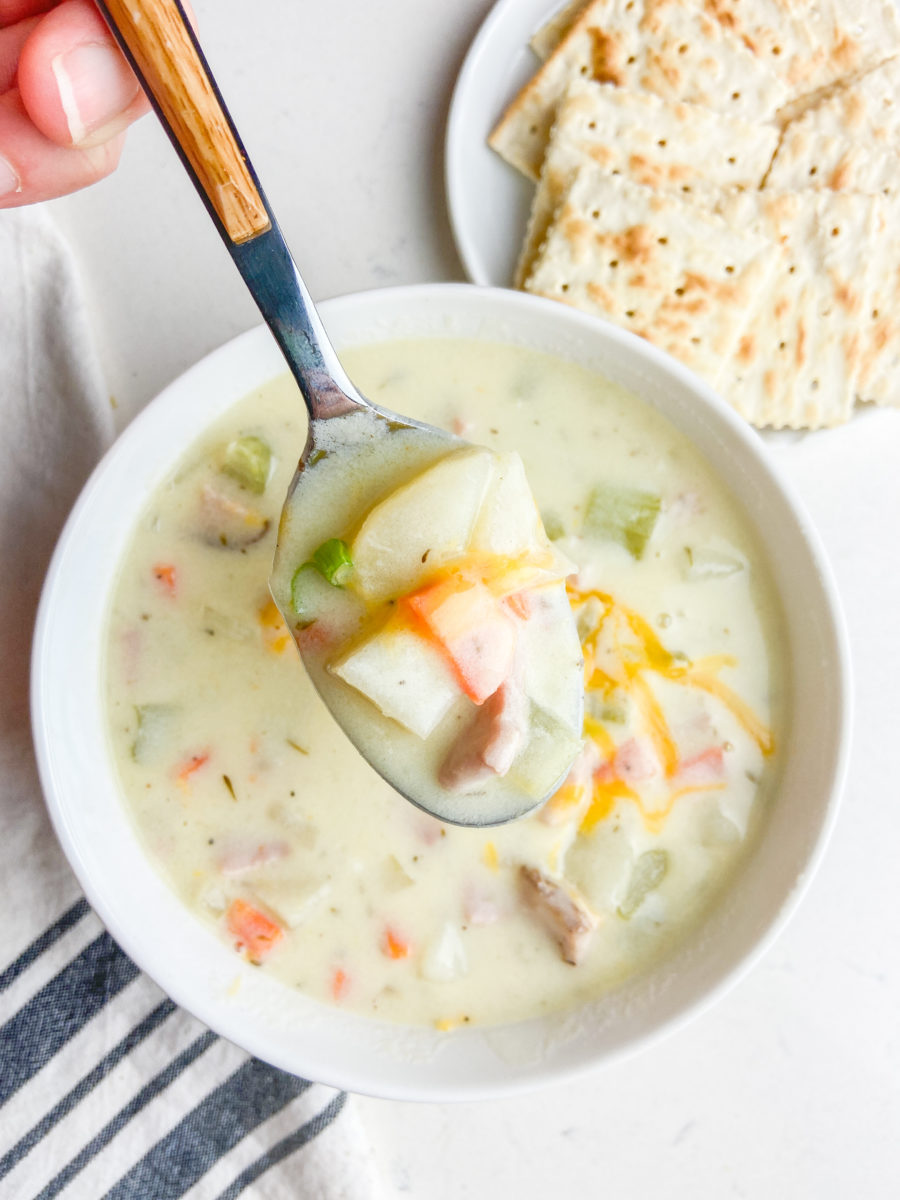 A  spoonful of creamy potato and ham soup. 