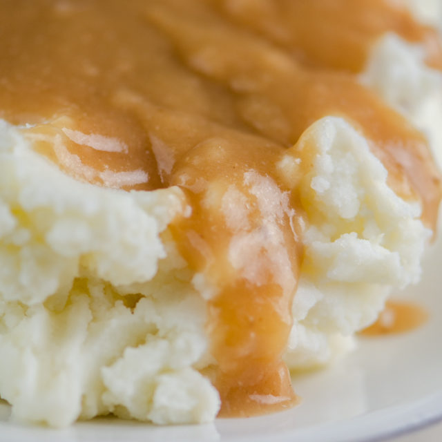 Close up side shot of gravy on mashed potatoes