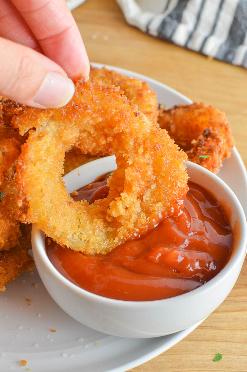 Dipping an onion ring in ketchup. 