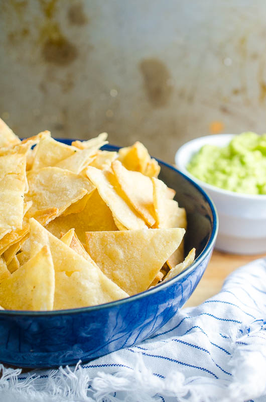 Homemade tortilla chips in a blue bowl.  