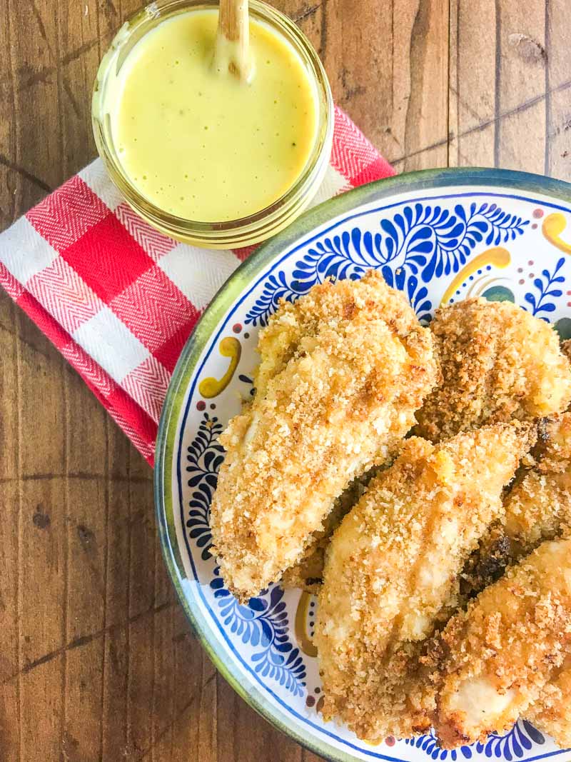 Baked Honey Mustard Chicken Tenders are marinated in honey mustard dressing, dredged in panko and baked until golden. They are a family favorite and perfect for weeknights!