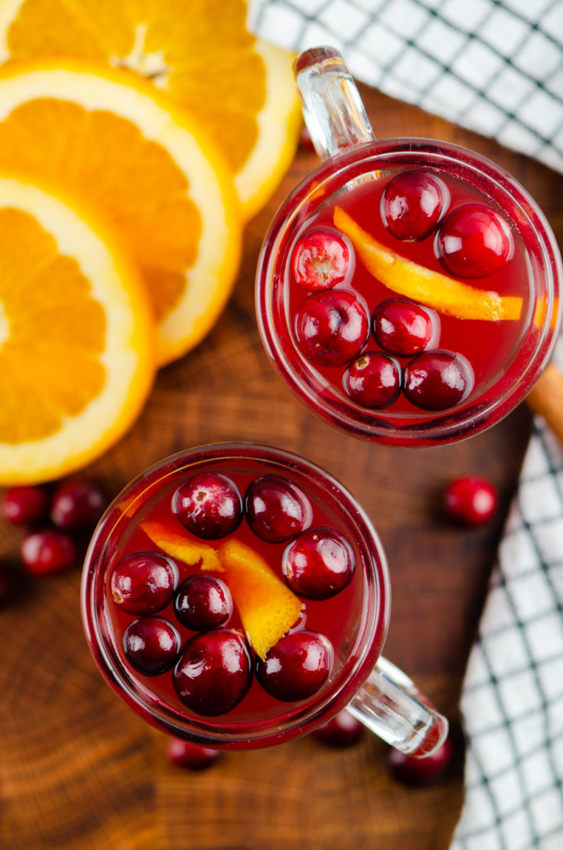 Overhead photo of two mugs of cranberry apple cider. 