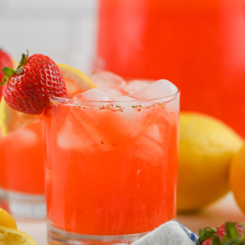 Strawberry Lemonade in a cup garnished with a strawberry.