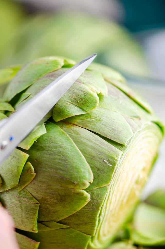 Trimming the leaves of an artichoke with scissors. 