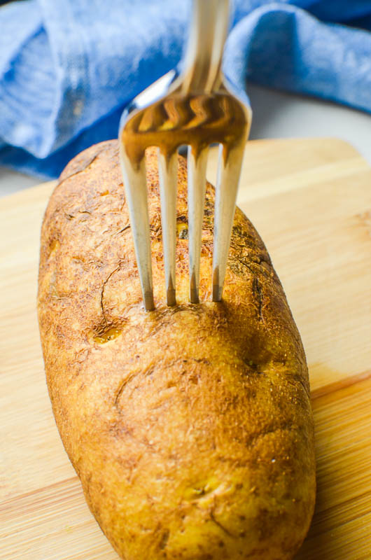 Poking holes in a baked potato with a fork. 