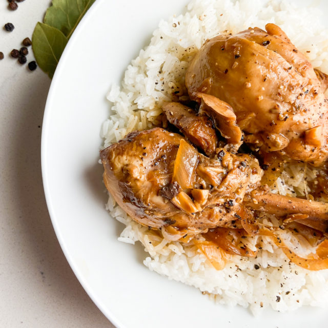 Closeup overhead photo of chicken adobo in white bowl.