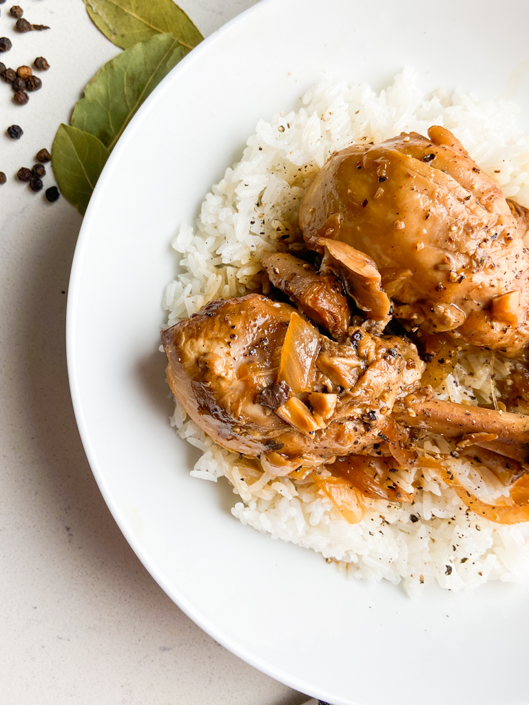 Closeup overhead photo of chicken adobo in white bowl.