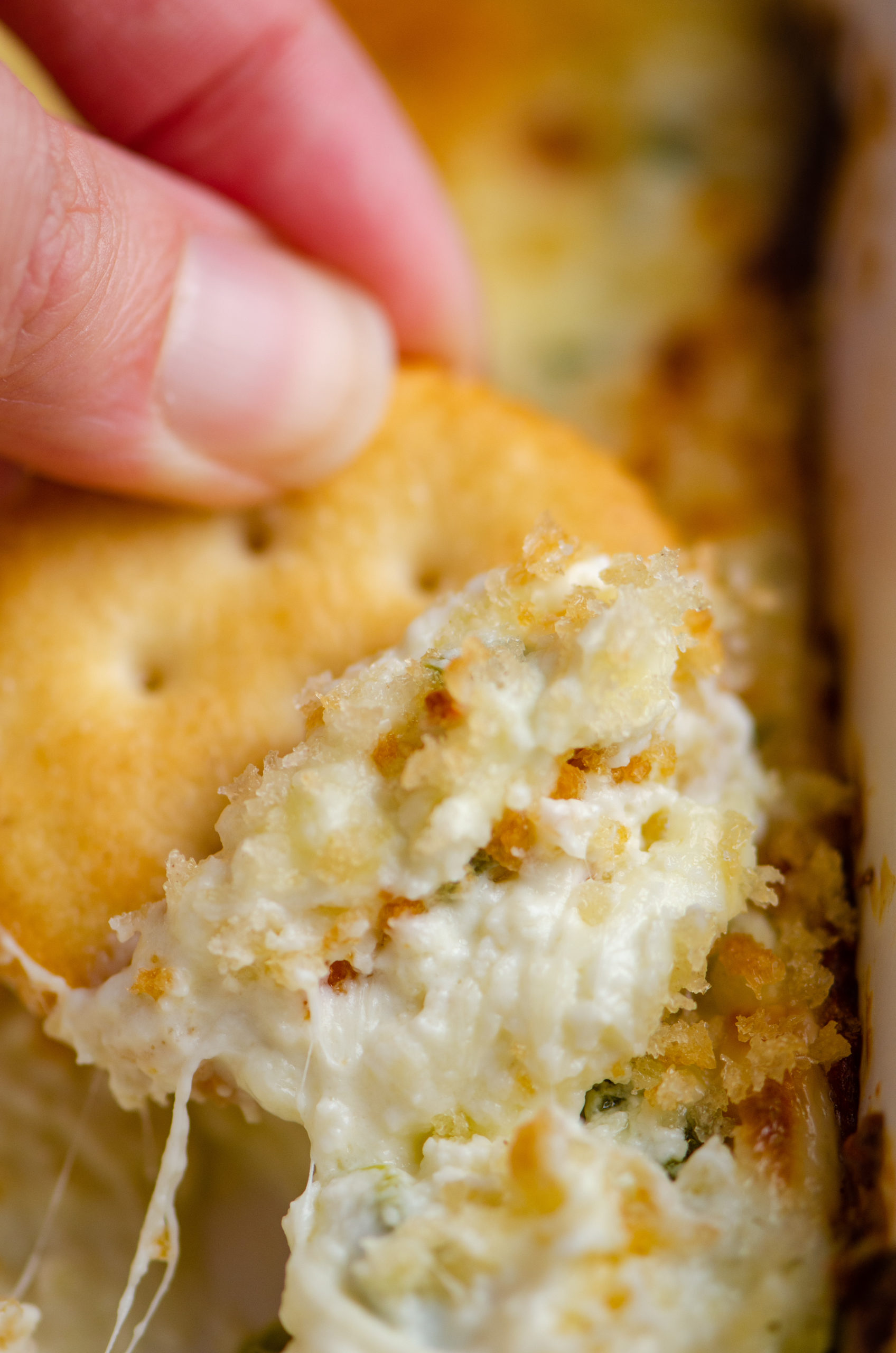 A scoop of jalapeno popper dip on a cracker. 
