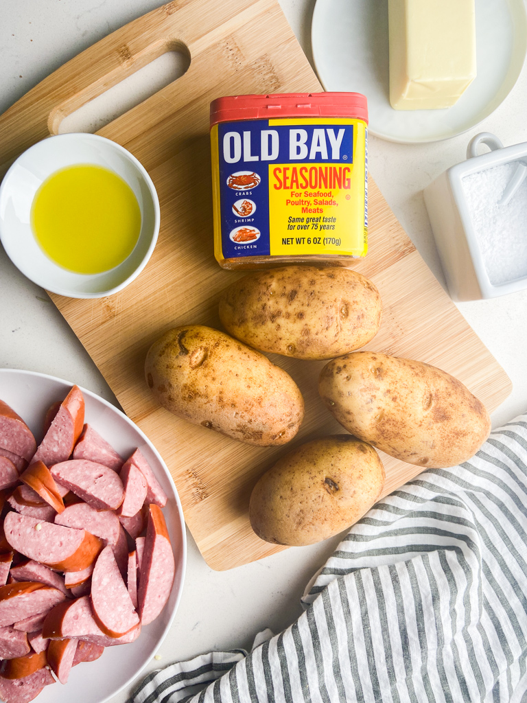  Overhead bilder av ingredienser som trengs for å lage stekt kielbasa og poteter. 