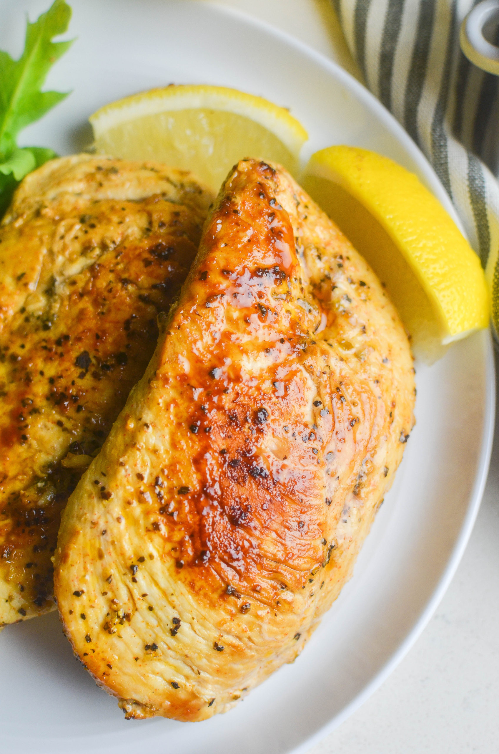 Lemon Pepper Chicken on a white plate with a lemon wedge