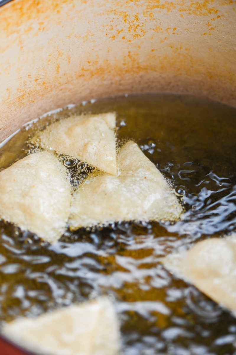 Tortilla chips frying in oil. 