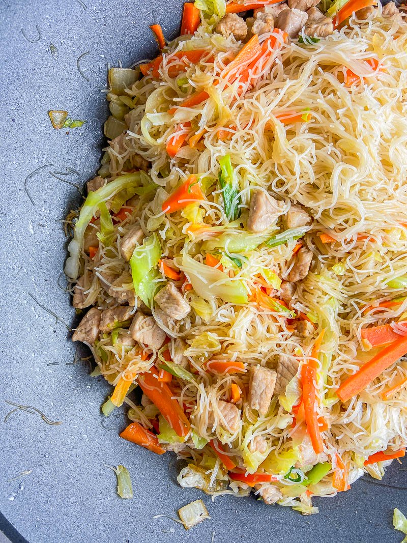 Filipino Pancit with pork and vegetables in a wok