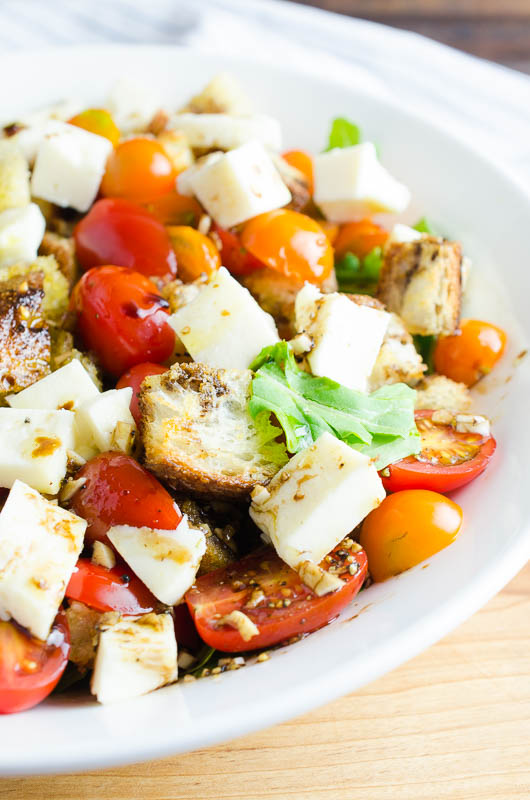 Panzanella Salad is a Tuscan salad with bread, tomatoes, herbs and a simple vinaigrette. It's the perfect way to enjoy summer tomatoes! 