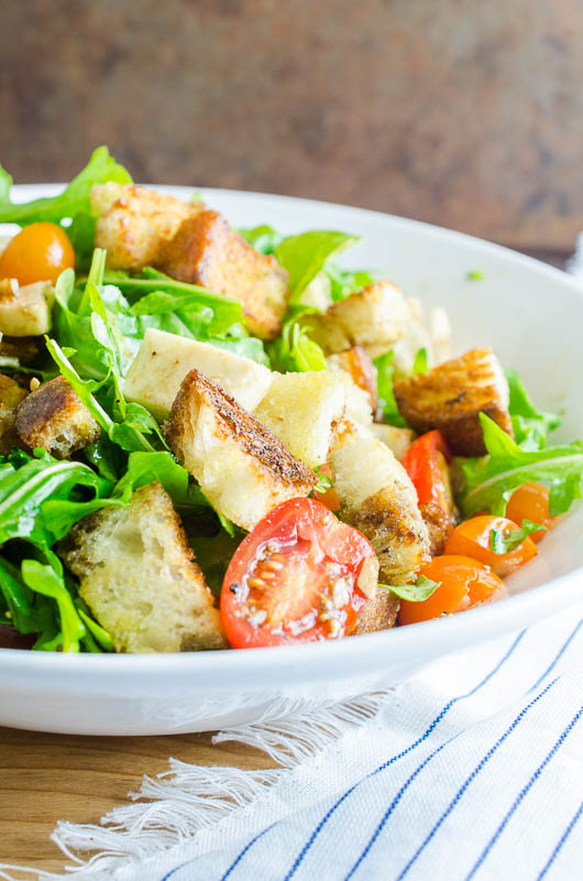 Panzanella Salad is a Tuscan salad with bread, tomatoes, herbs and a simple vinaigrette. It's the perfect way to enjoy summer tomatoes! 