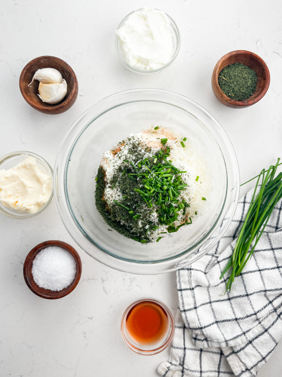 Parmesan ranch dip in clear glass bowl on white background. 