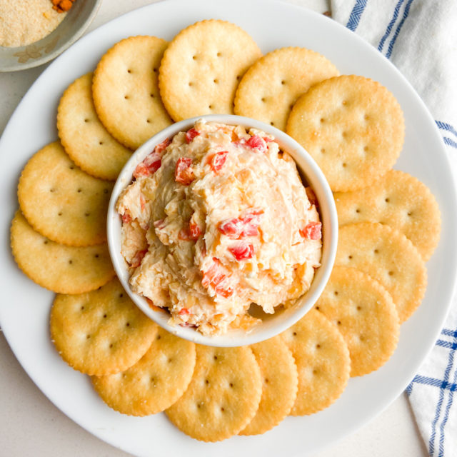 Overhead photo of pimento cheese and crackers on a white plate.