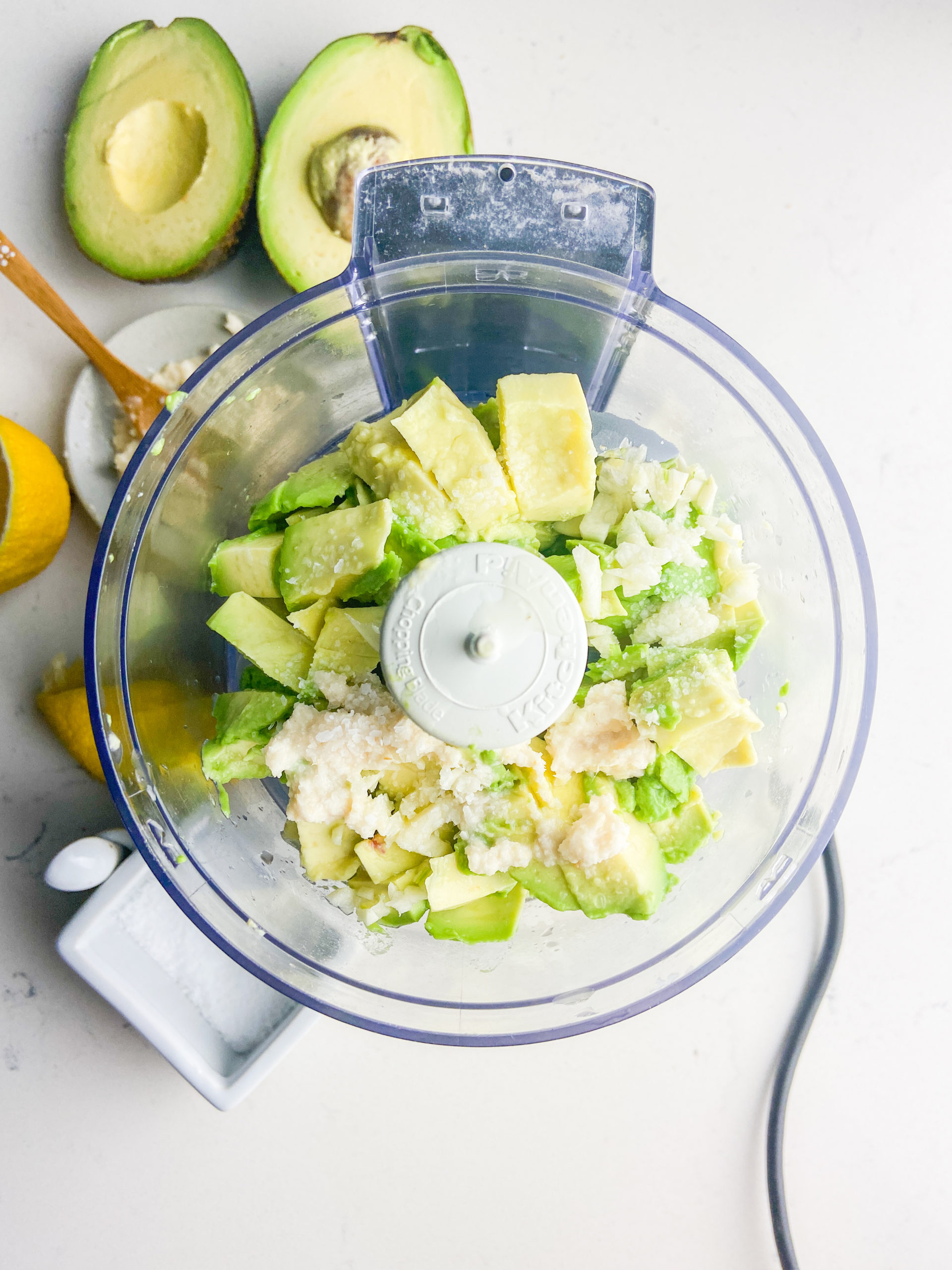 Ingredients for avocado sauce in a mini food processor. 