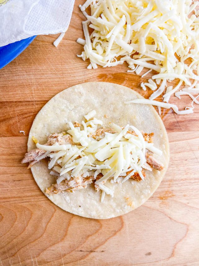 Overhead photo of pork filling on a corn tortilla. 