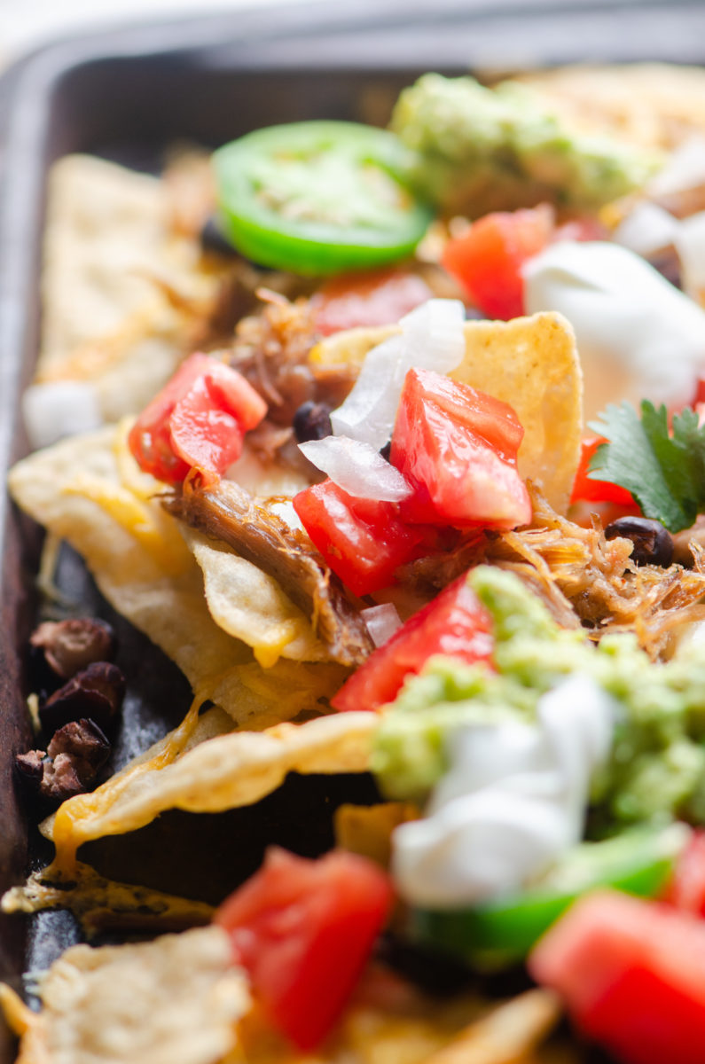Side view of nachos on a baking sheet. 