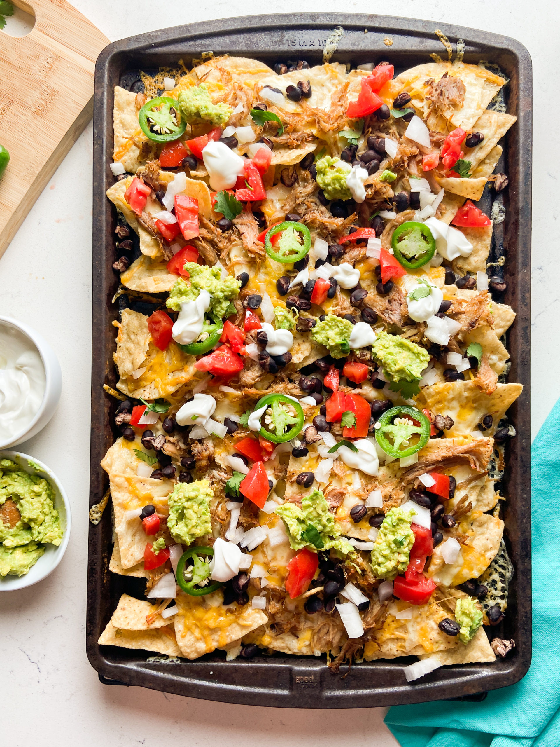 Overhead photo of shredded pulled pork sheet pan nachos. 