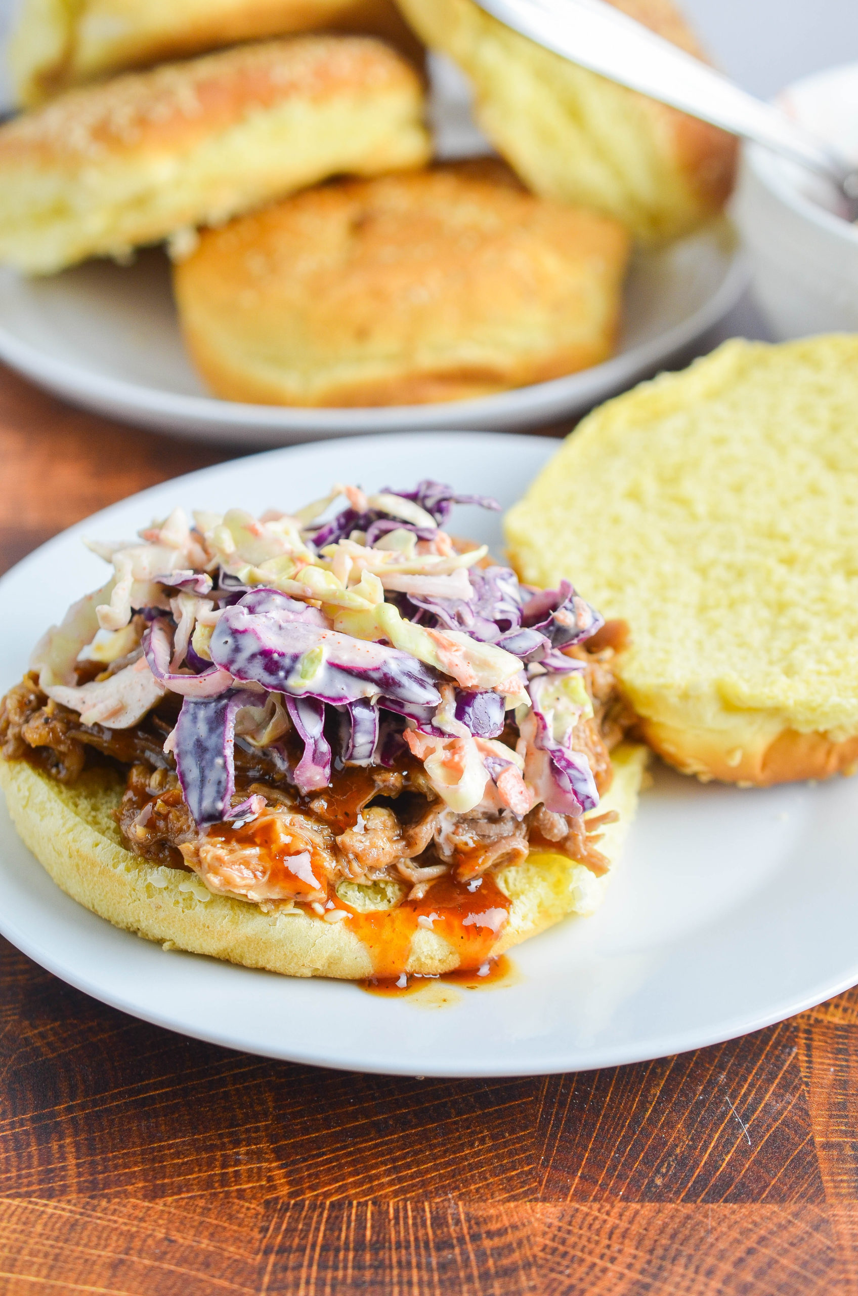 BBQ pulled pork sandwich on a white plate. 