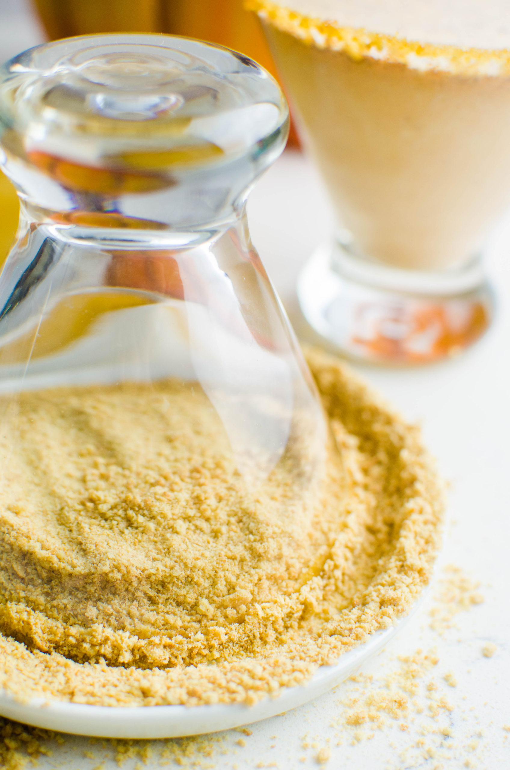 Pressing martini glass in graham cracker crumbs. 