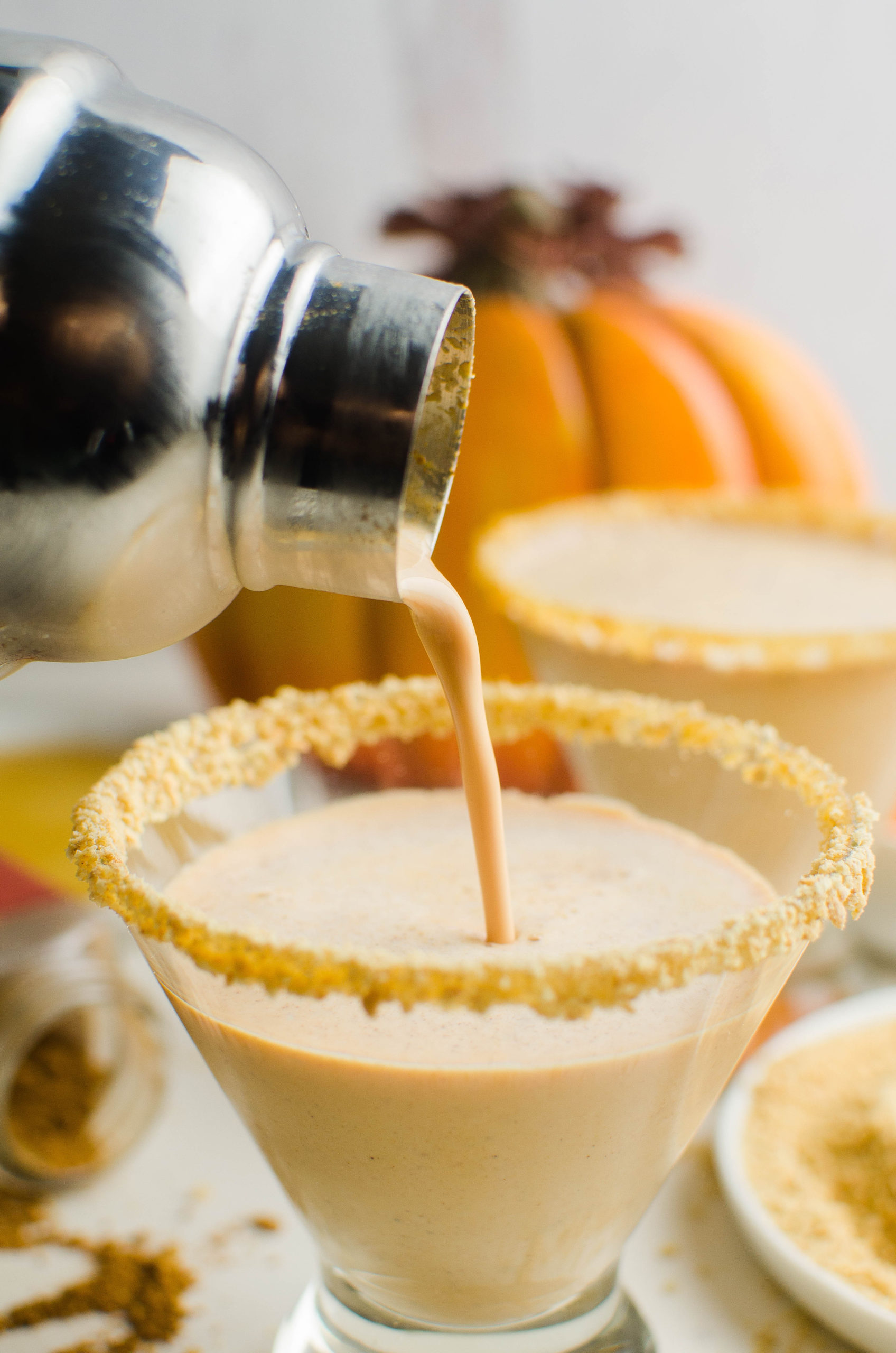 Pouring pumpkin martini into glass. 