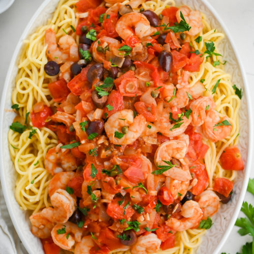 Overhead photo of shrimp puttanescaa pasta on oval plate.