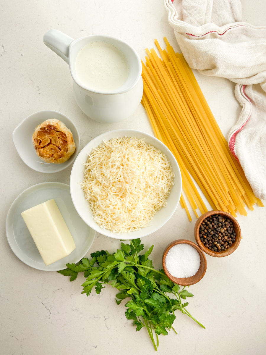 Overhead photos of ingredients needed to make roasted garlic alfredo. 