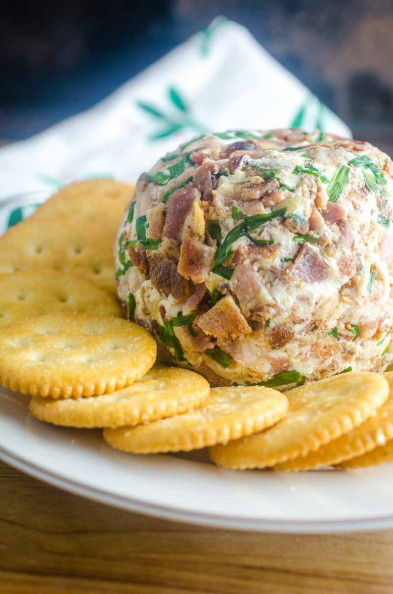 This Roasted Garlic Cheese Ball is a party must have. With Roasted Garlic, Bacon, Goat Cheese and Chives, this Easy Cheese Ball Recipe will be a favorite for years to come! 