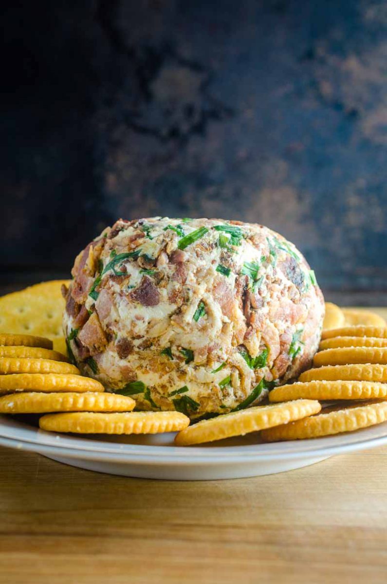 This Roasted Garlic Cheese Ball is a party must have. With Roasted Garlic, Bacon, Goat Cheese and Chives, this Easy Cheese Ball Recipe will be a favorite for years to come! 