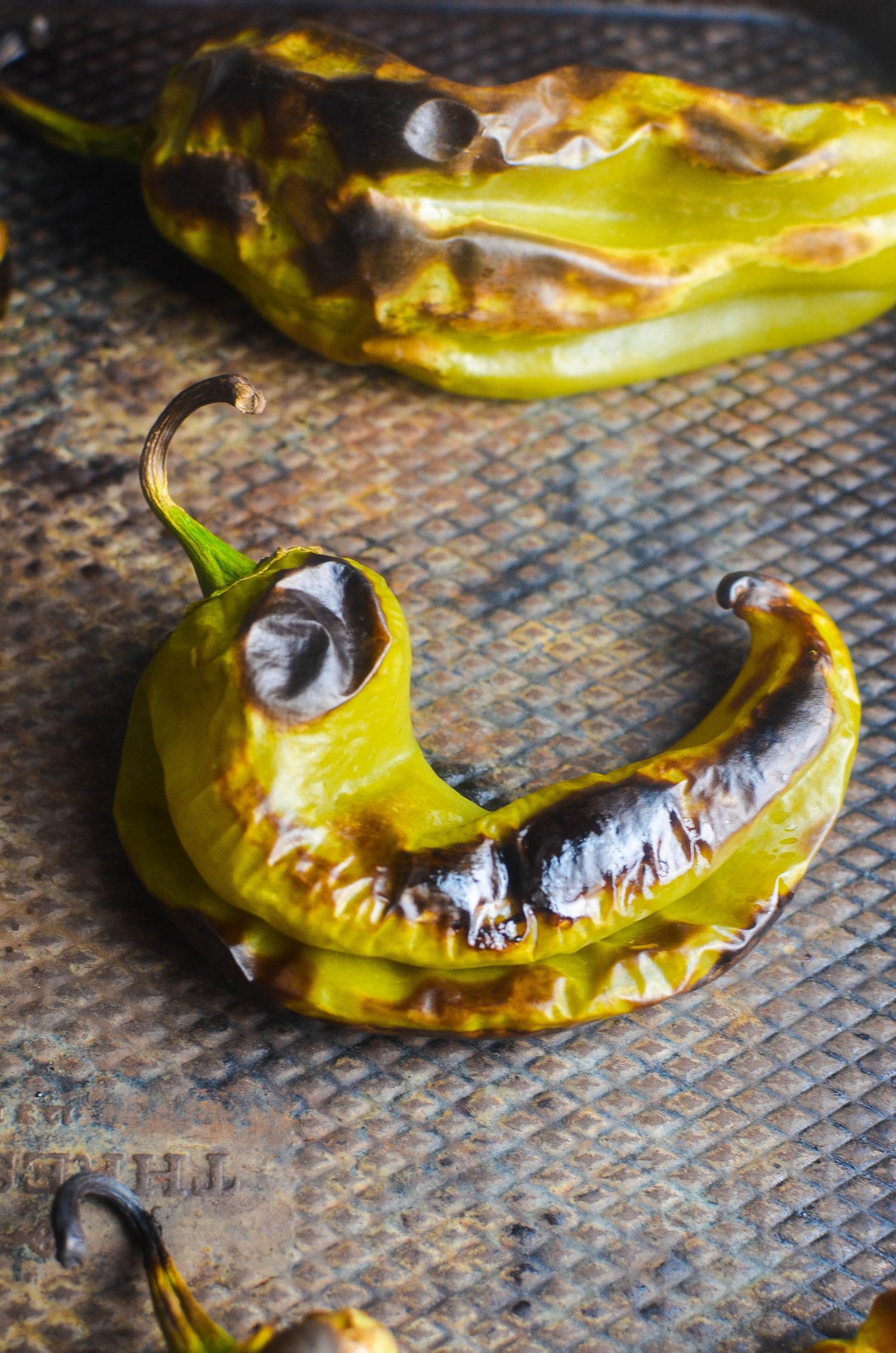 Close up of roasted hatch chile on baking sheet. 