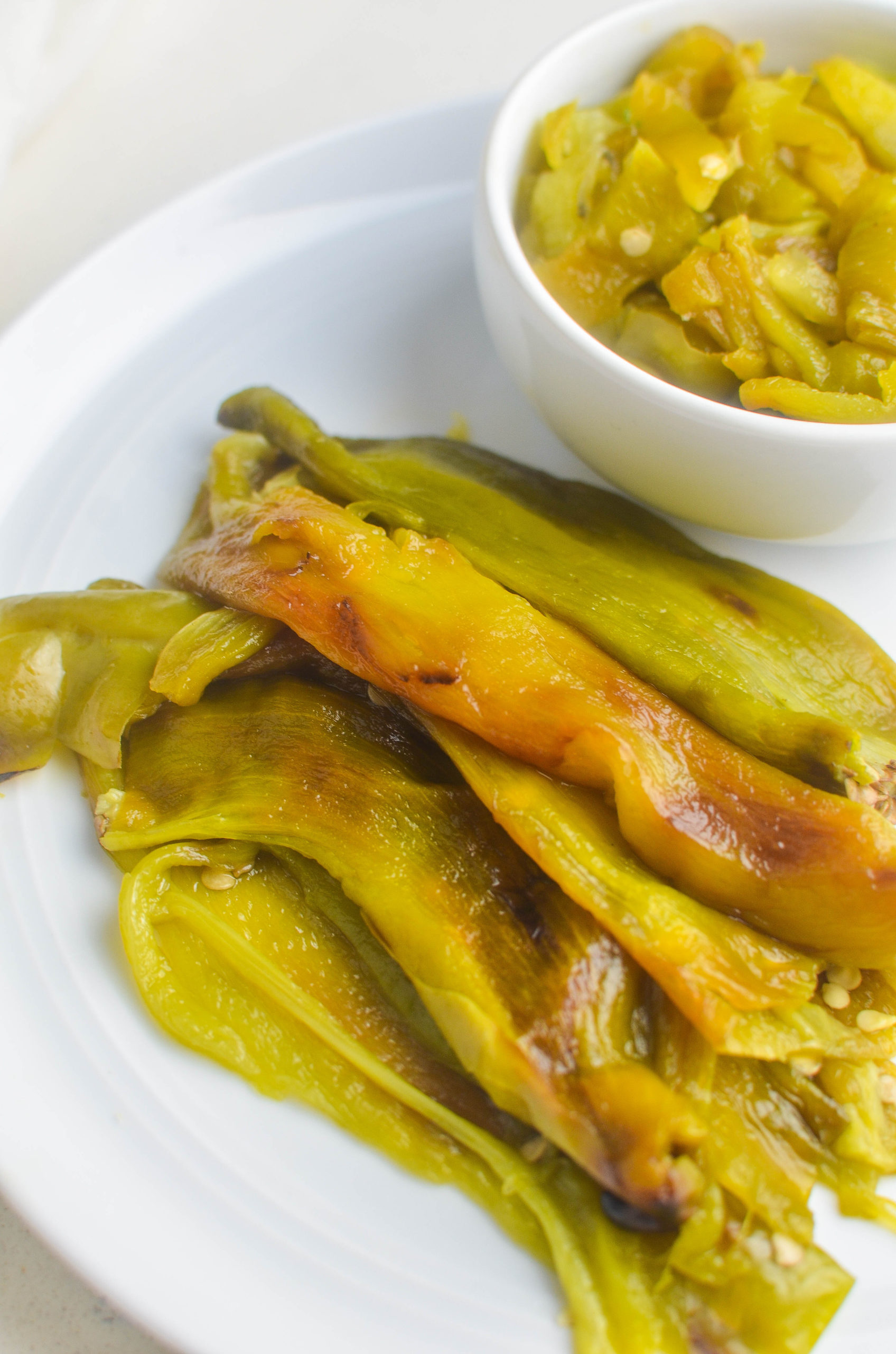 Roasted chiles on a white plate. Diced chiles in a bowl. 