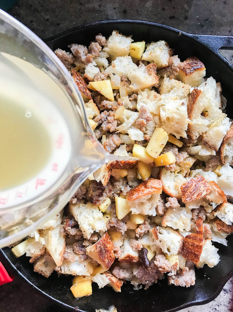 Adding chicken broth to stuffing. 