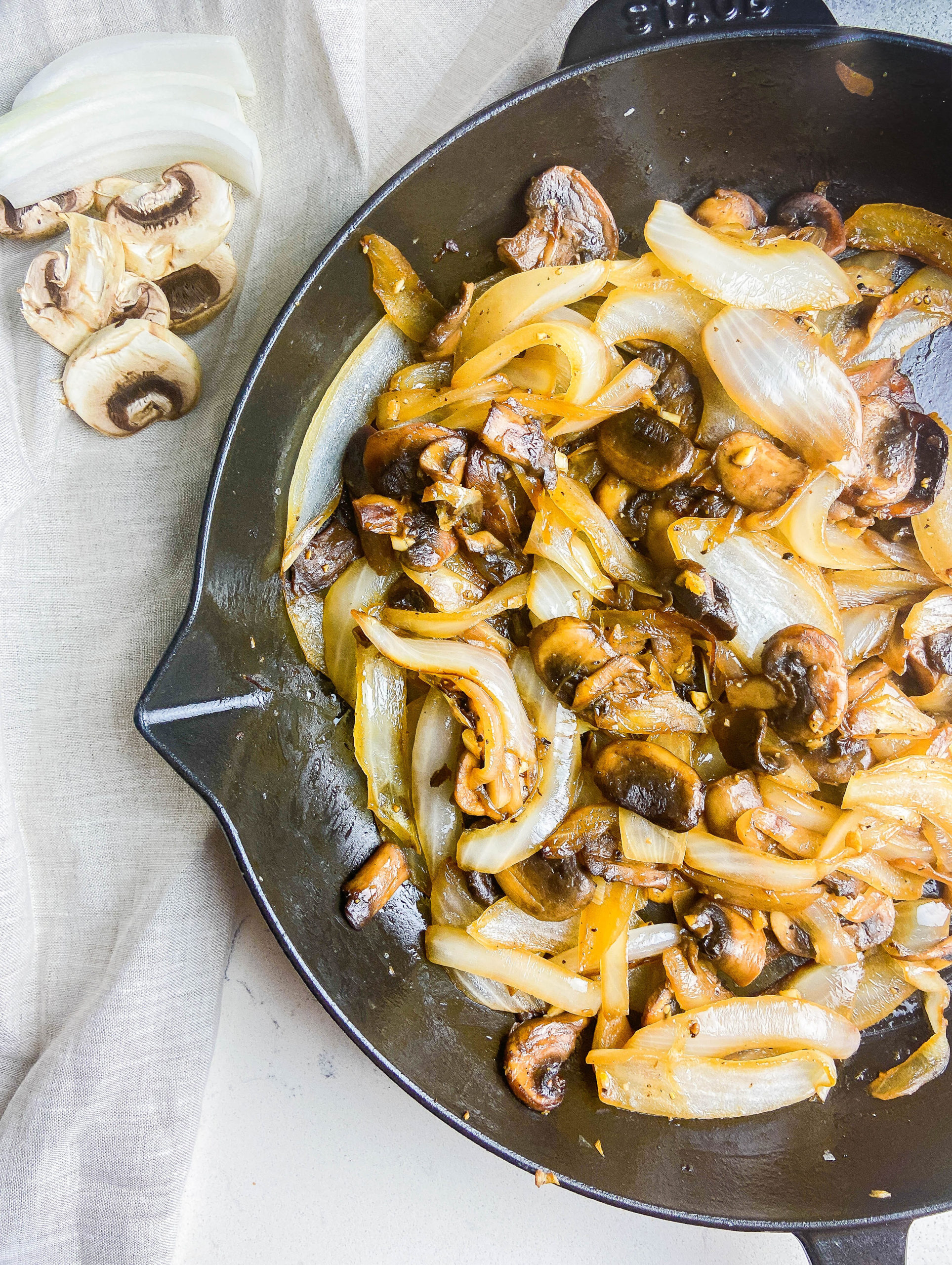 Overhead photo of sauteed mushrooms and onions in a cast iron skillet. 