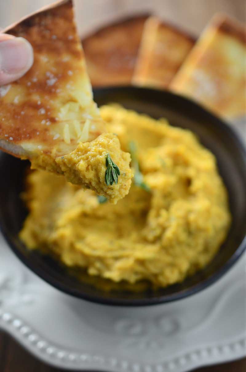 A savory pumpkin hummus with pumpkin, garlic, thyme and rosemary. The perfect dip for holiday get togethers!