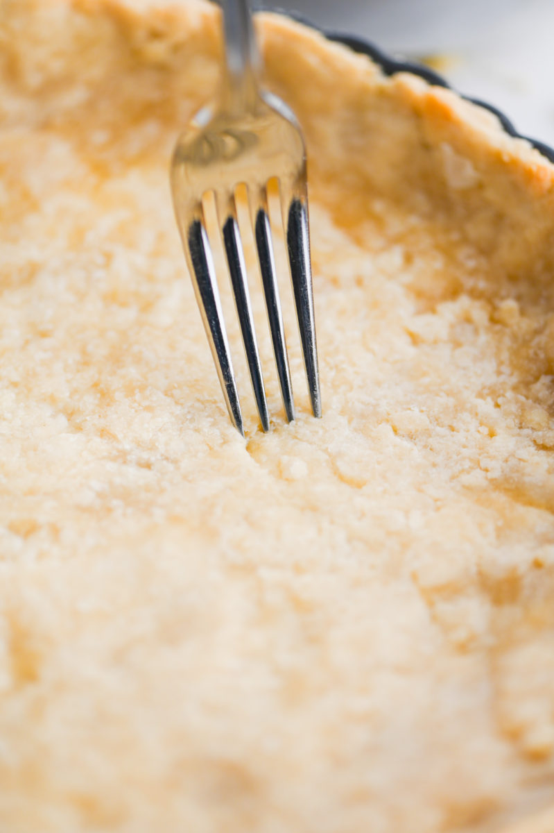 A fork pricking tart dough. 