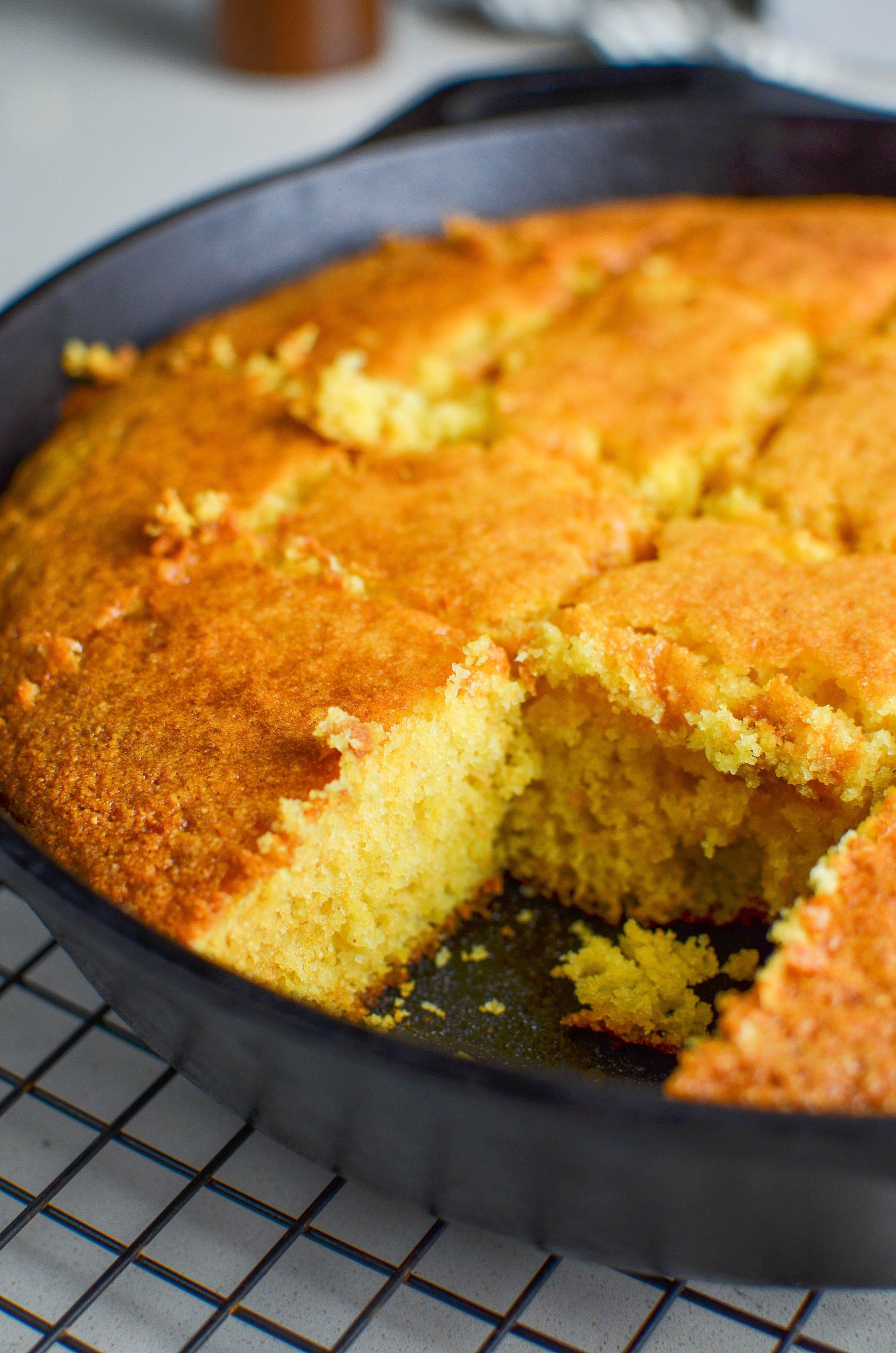 Side angle photo of sliced cornbread in a skillet. 