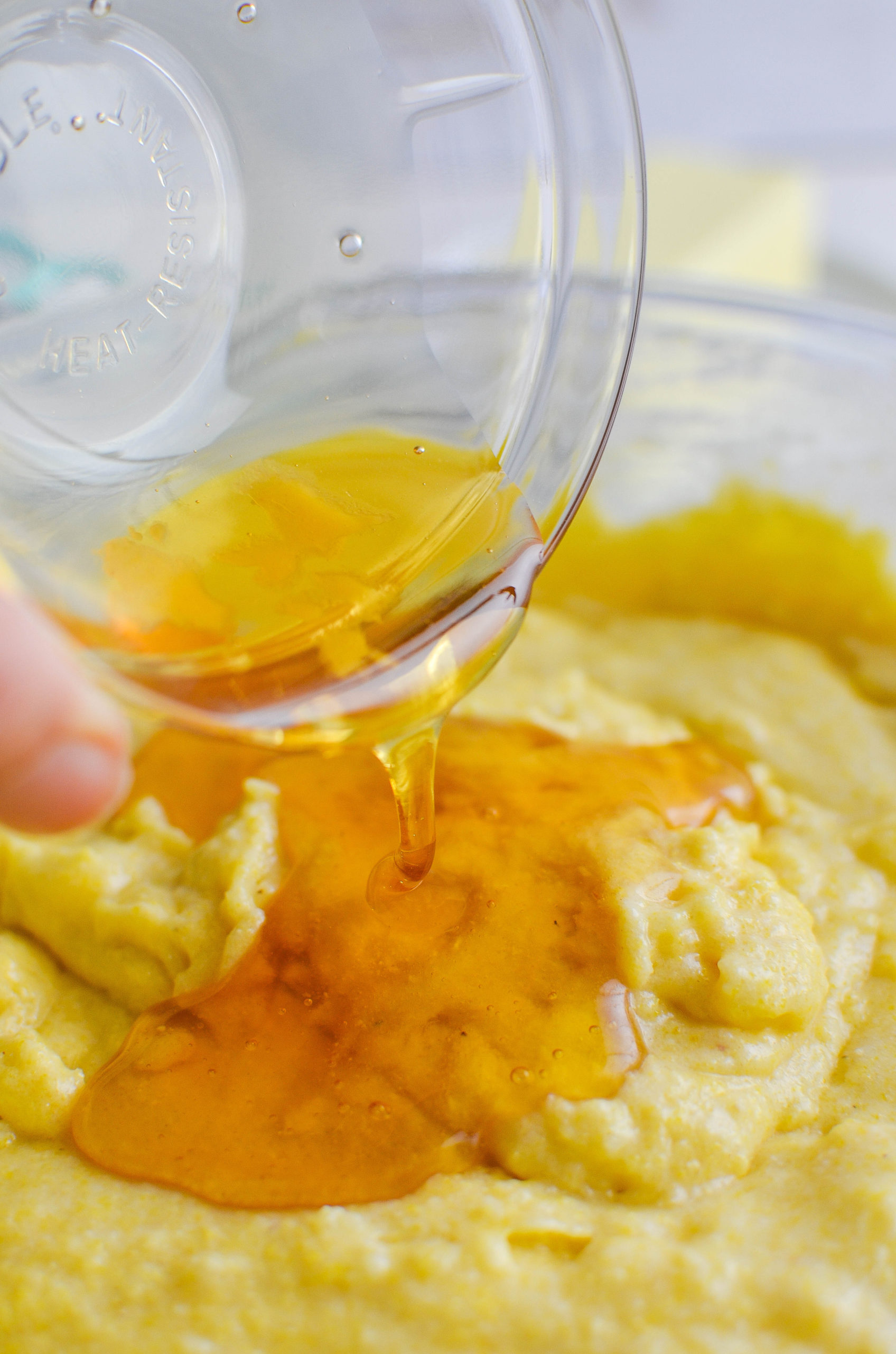 Pouring honey into bread batter. 