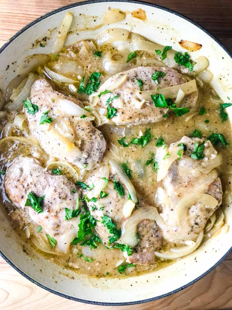 Smothered Pork Chops are a classic for a reason! These sage rubbed pork chops are pan fried and simmered in a savory onion gravy. It's comfort food at it's finest! 