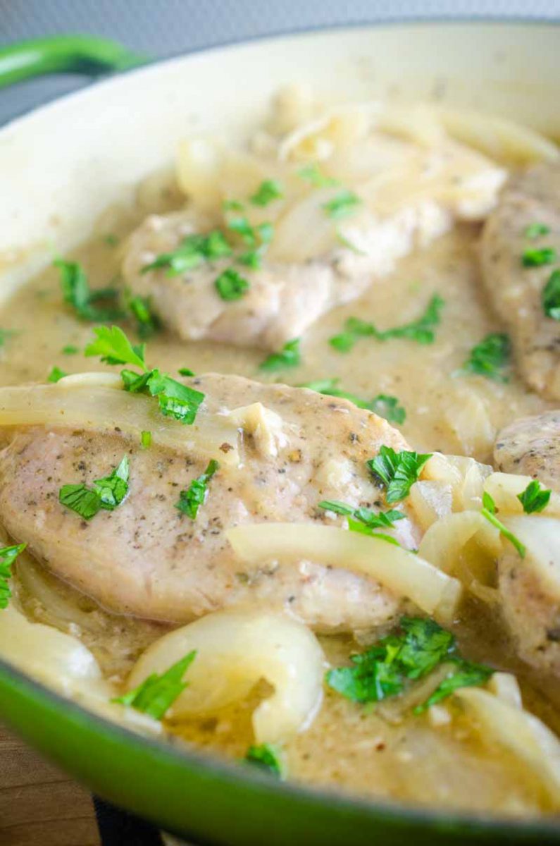 Smothered Pork Chops are a classic for a reason! These sage rubbed pork chops are pan fried and simmered in a savory onion gravy. It's comfort food at it's finest! 