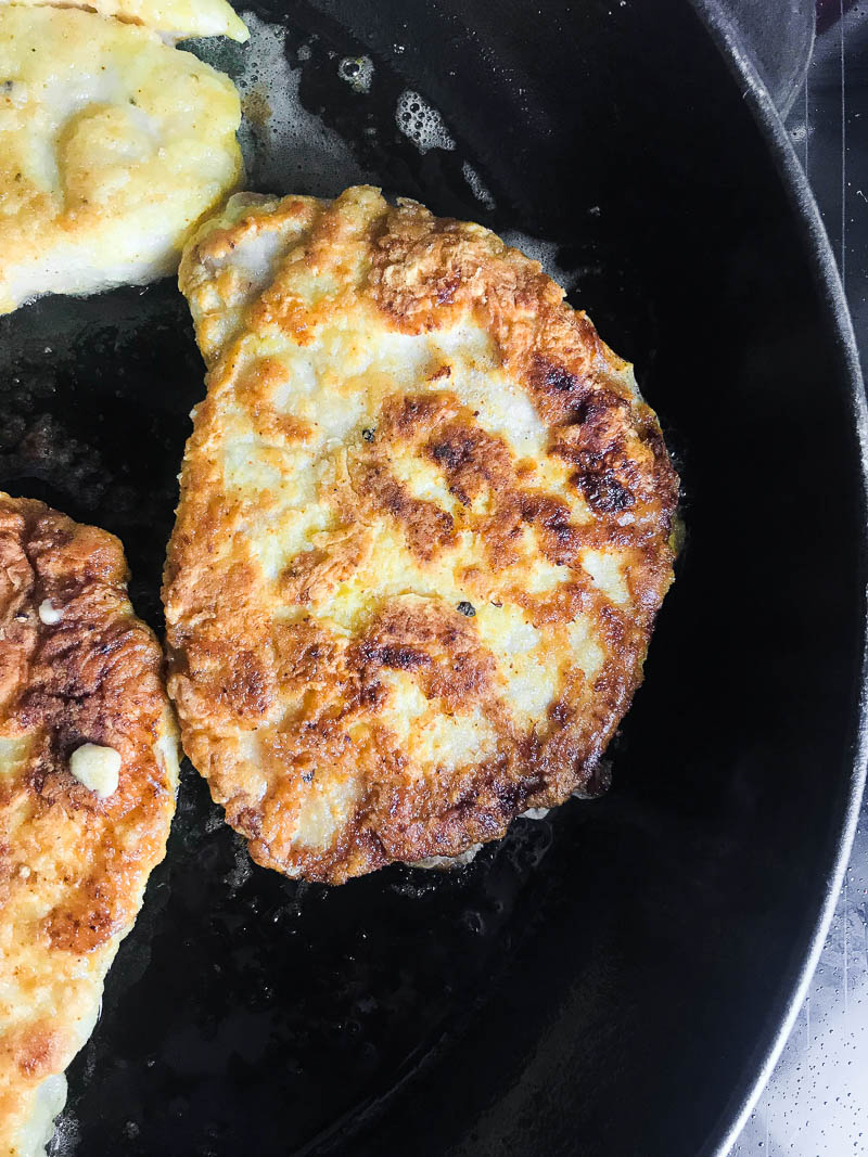 Pork chops frying in a pan. 