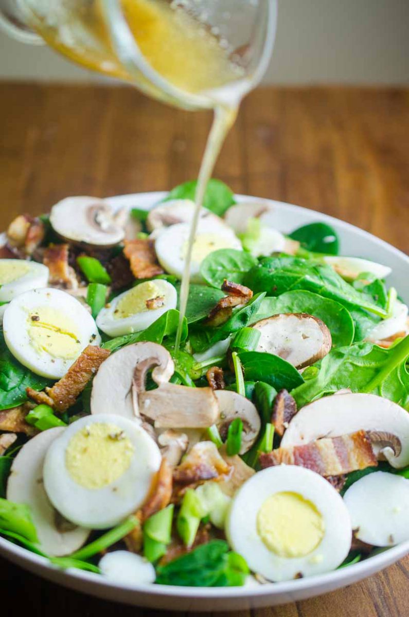 Spinach Salad with Bacon Dressing is a classic for a reason. Fresh spinach tossed with mushrooms, crispy bacon, hard boiled eggs and tossed with a warm bacon dressing. 