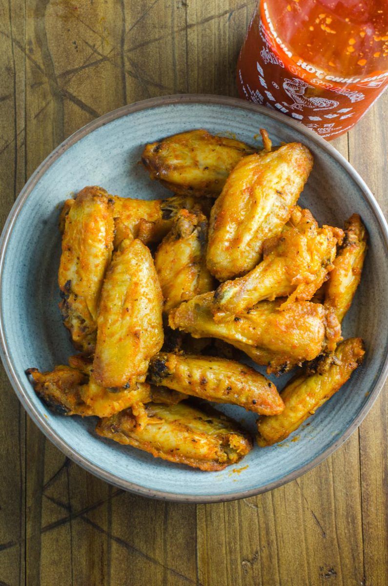 Sriracha Chicken Wings are baked to perfection and then tossed in a spicy sriracha sauce. They will be your new favorite chicken wing!