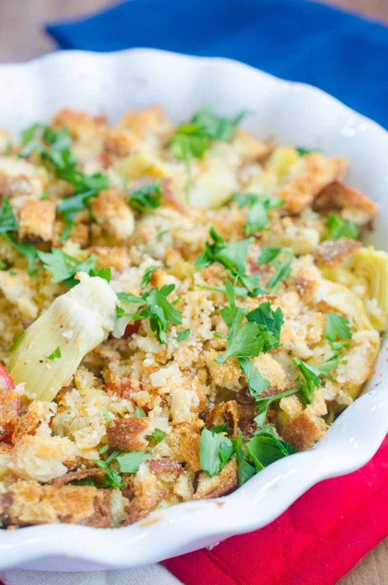 Tomato Artichoke Bake is the perfect side! It's loaded with artichoke hearts, fresh bread crumbs, tomatoes, grated parmesan and then baked until golden.