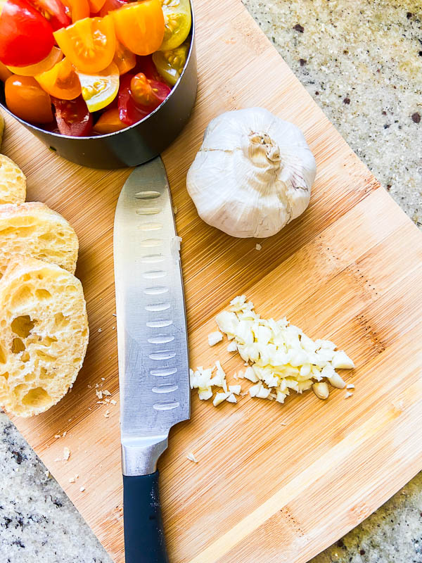 Minced garlic on a wooden cutting board. 
