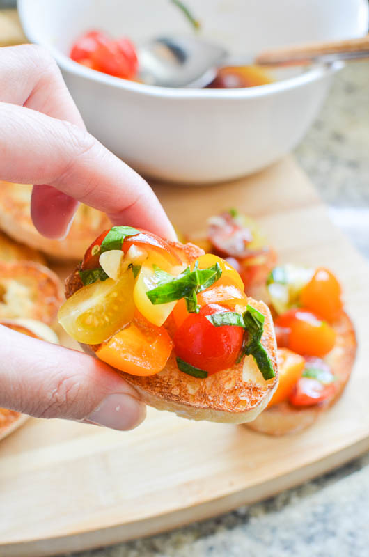 Hand holding tomato bruschetta. 