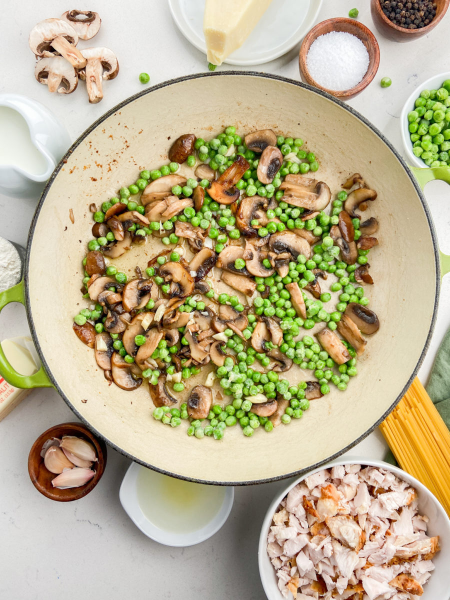 Sauted mushrooms and peas in pan. 