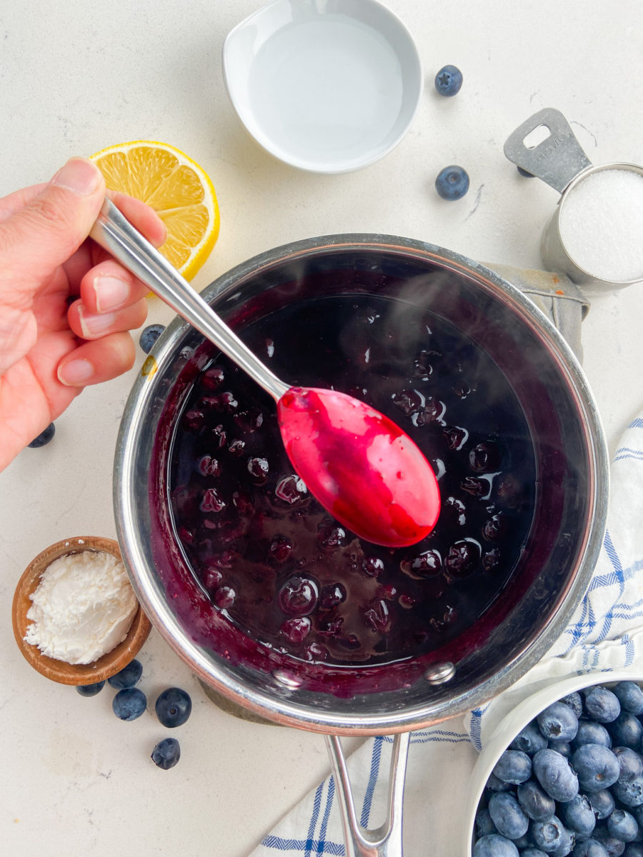 Blueberry sauce coating the back of a spoon. 